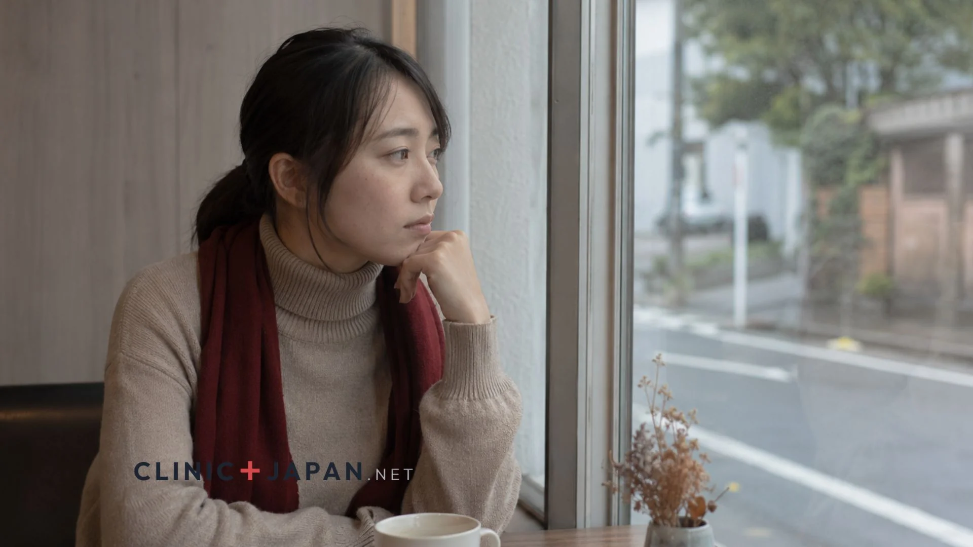 窓際で物思いにふける女性 — 二重整形の失敗を客観的に振り返る