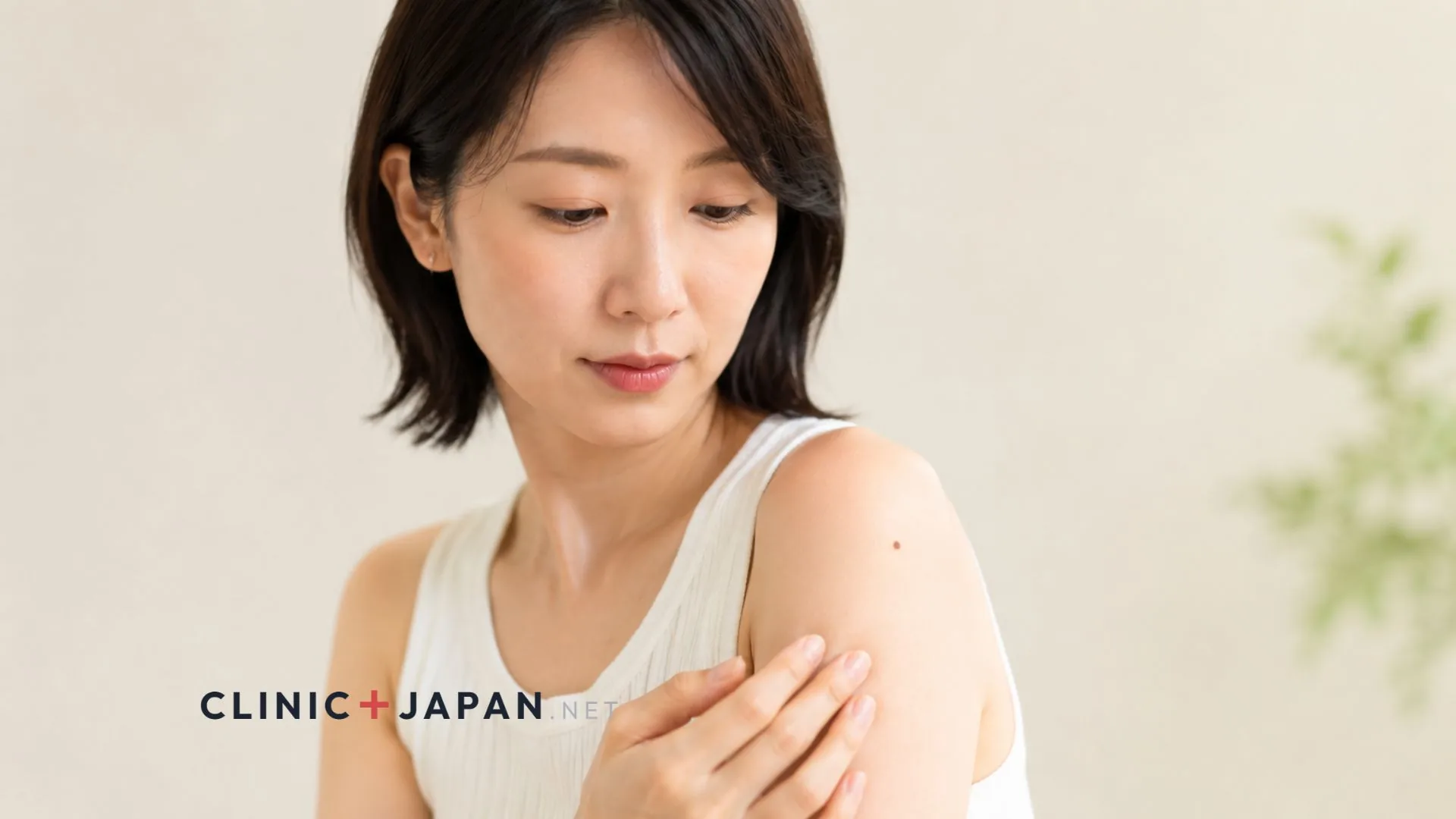 腕のほくろを確認しながら医療脱毛を検討する30代女性